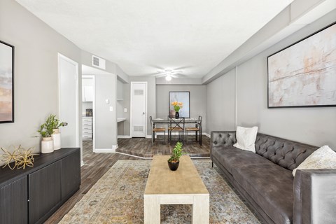 A living room with a grey couch, a coffee table, and a painting on the wall.